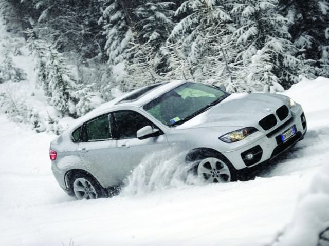 Белый автомобиль во время езды по снежной дороге