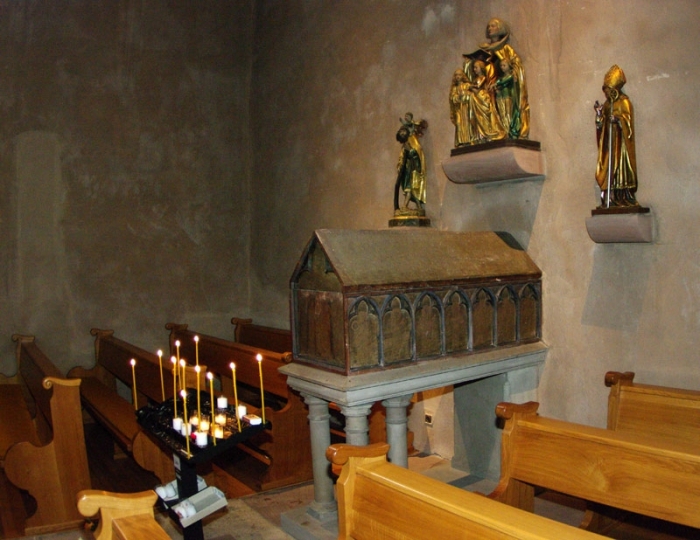 Над саркофагом расположены скульптуры (слева-направо): св. мученика Христофора (250), свв. мучениц Веры, Надежды, Любови и Софии, епископа Ремигия, основателя аббатства.